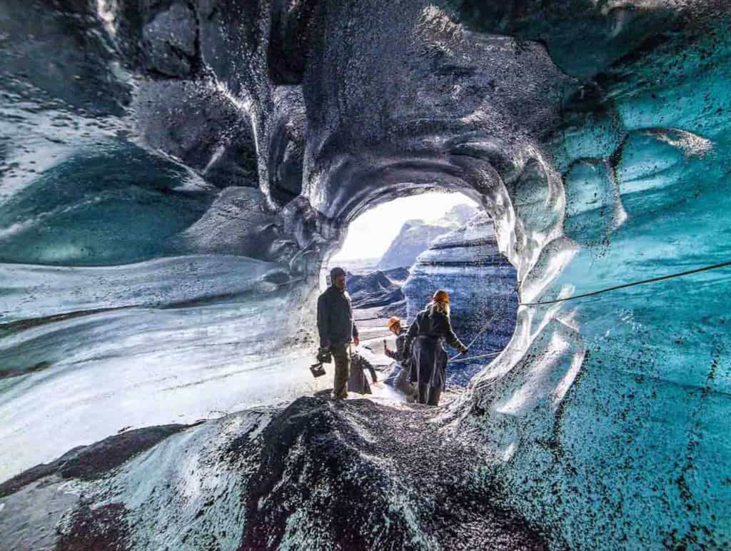 Tourists are exploring the black and blue walls of Katla Ice Cave.
